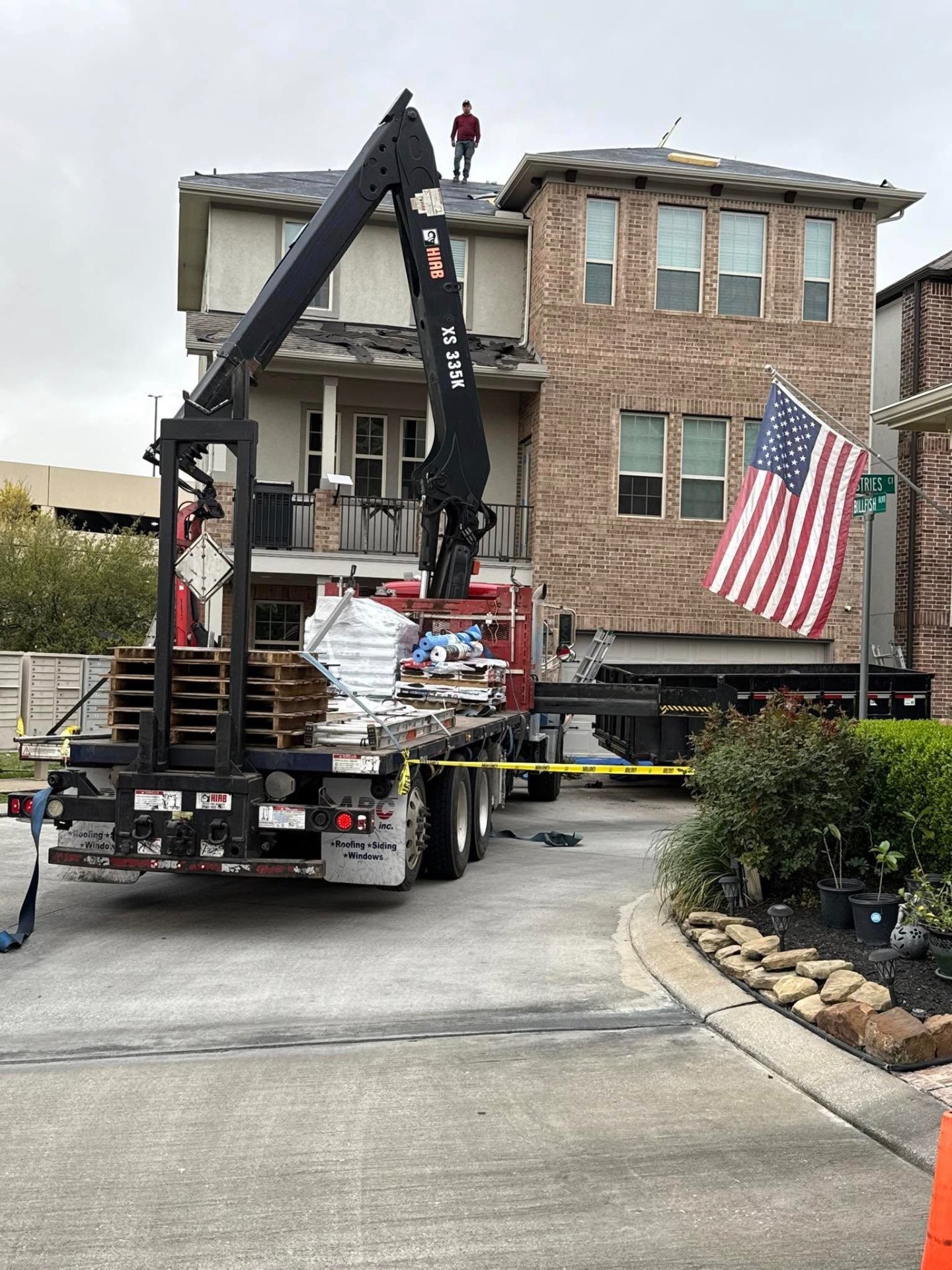CCS crane truck delivering shingles to a Houston home