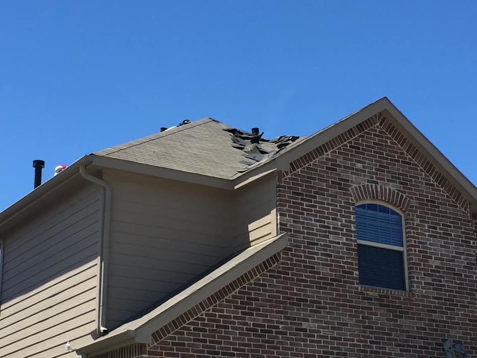 Storm-damaged shingles on a Houston home